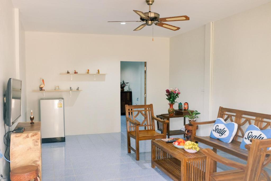 a living room with a table and chairs and a refrigerator at Green tree house 度假屋 in Ko Chang