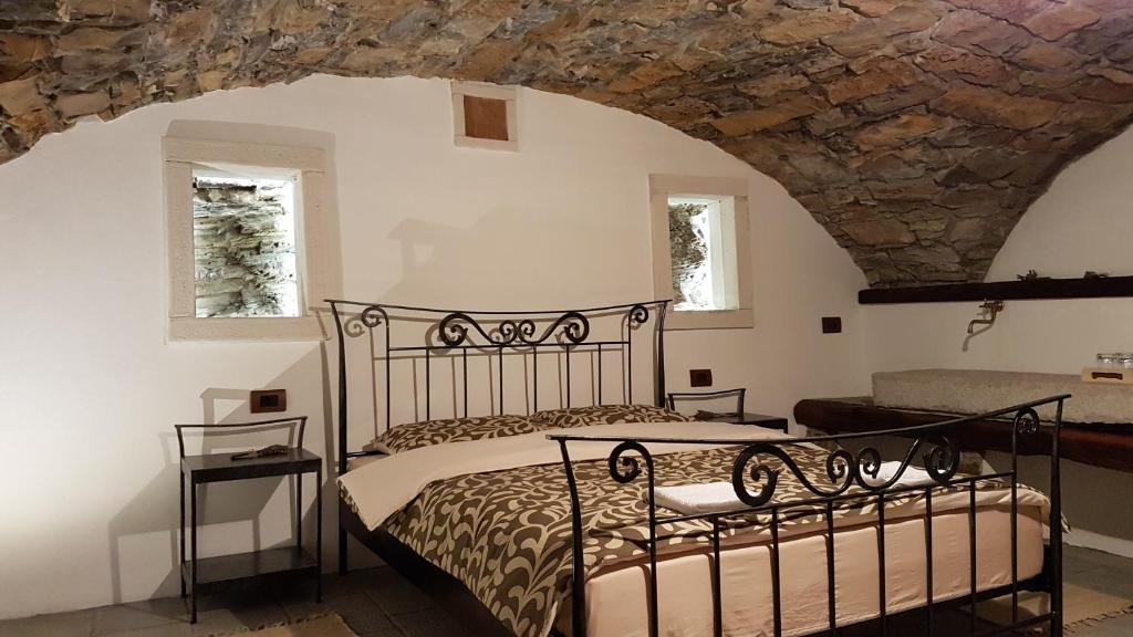a bedroom with a bed and a stone wall at Wine cellar room in Vipava