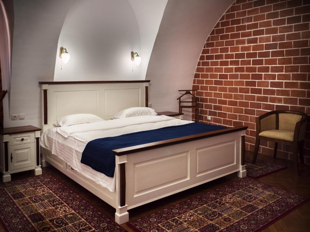 een slaapkamer met een bed en een bakstenen muur bij Gothic Central Sibiu in Sibiu