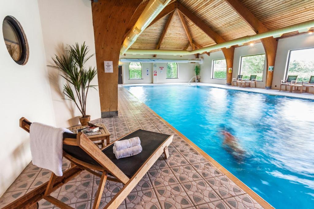 a pool in a hotel with a chair in the middle at Lake District Castle Inn Hotel and Spa in Keswick