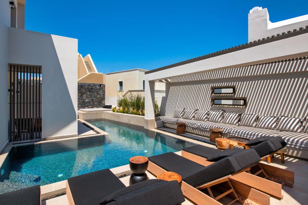 a swimming pool in the backyard of a house at Uma Ray Suites in Fira