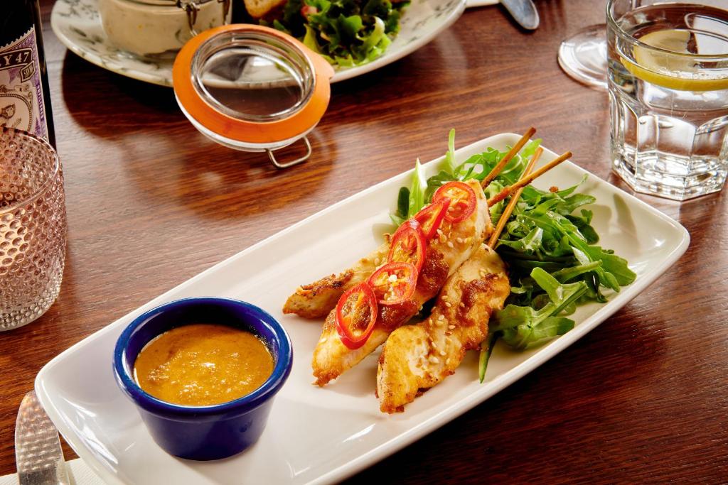 a plate of food with chicken and salad on a table at The Jug And Bottle in Heswall