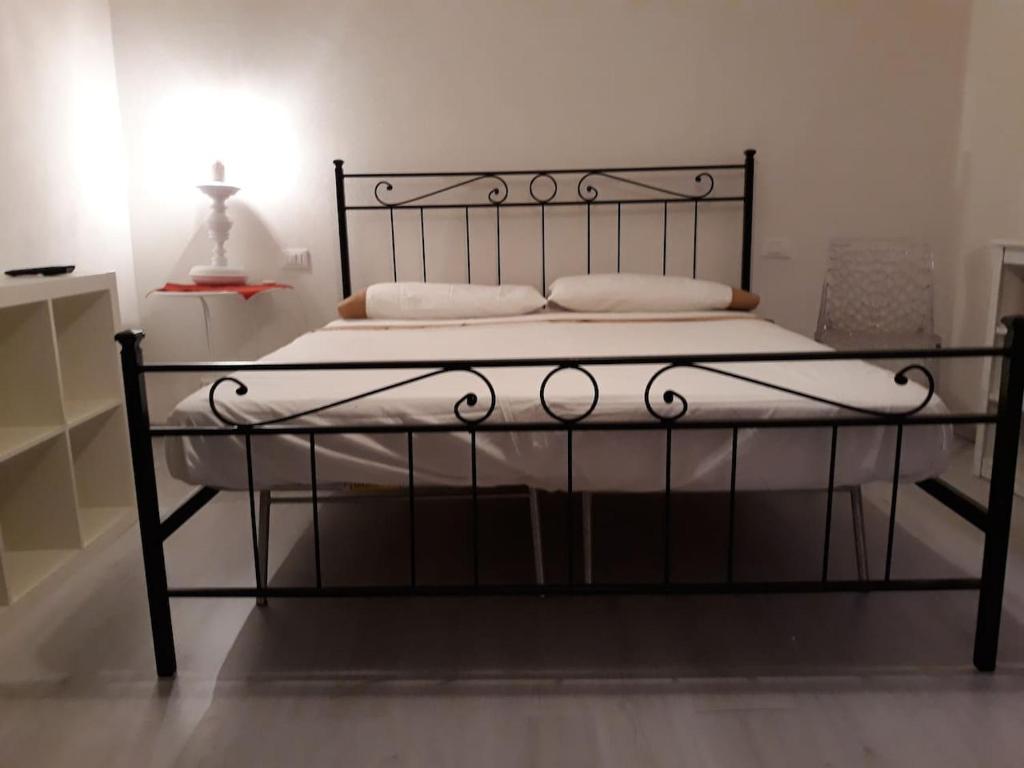 ein schwarzes Bett mit weißer Bettwäsche und Kissen darauf in der Unterkunft L' Antico Comune in Cavriglia