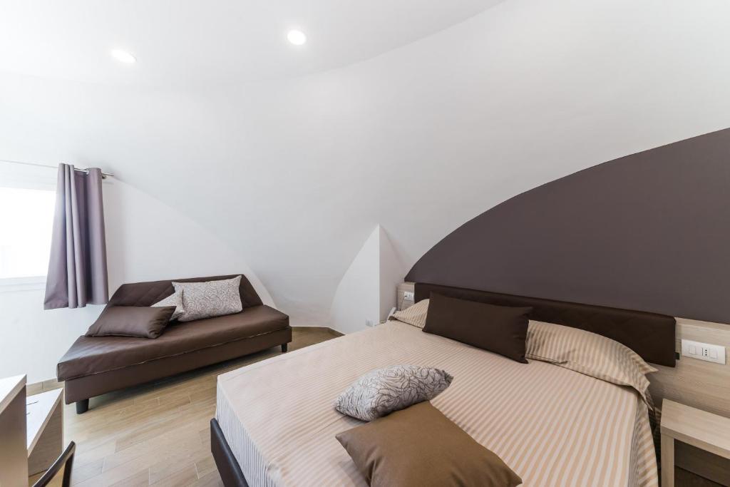 a bedroom with a bed and a couch at Torre Cintola Greenblu Sea Emotions in Monopoli