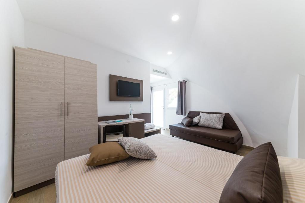 a living room with a bed and a couch at Torre Cintola Greenblu Sea Emotions in Monopoli