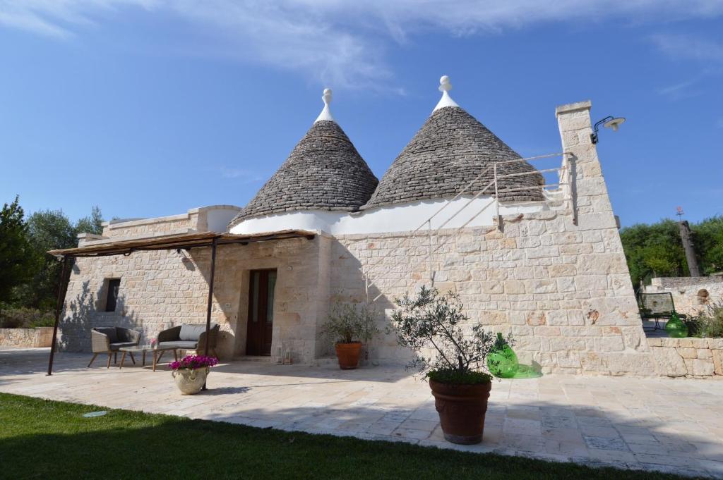 an external view of a stone house with a roof at La Corticella Bed & Breakfast in Martina Franca