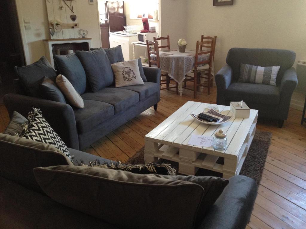 uma sala de estar com um sofá e uma mesa de centro em Le Coq En Pate em Péronne