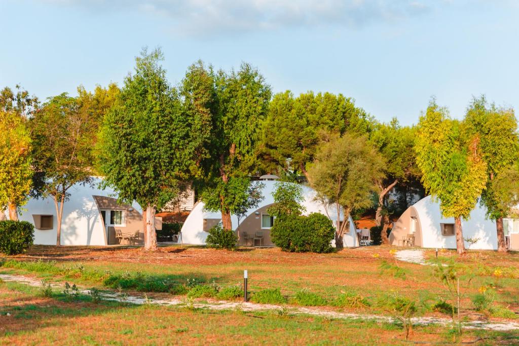 a row of houses with trees in the background at Torre Cintola Greenblu Sea Emotions in Monopoli