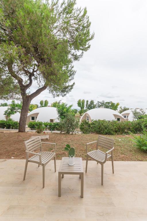 two chairs and a table and a tree at Torre Cintola Greenblu Sea Emotions in Monopoli