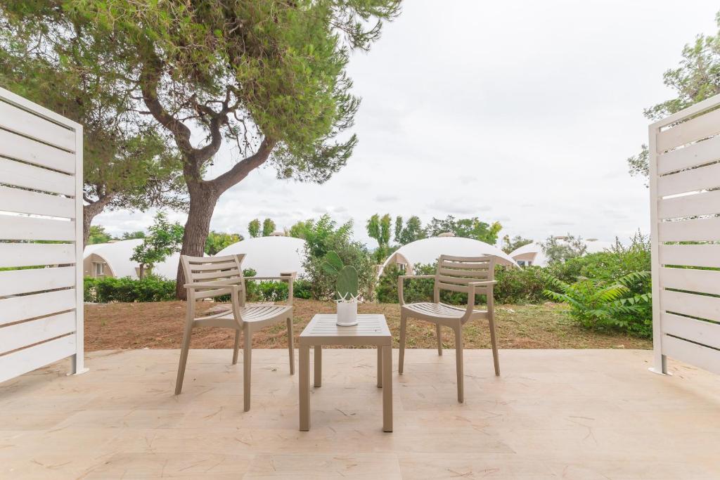 two chairs and a table on a patio at Torre Cintola Greenblu Sea Emotions in Monopoli