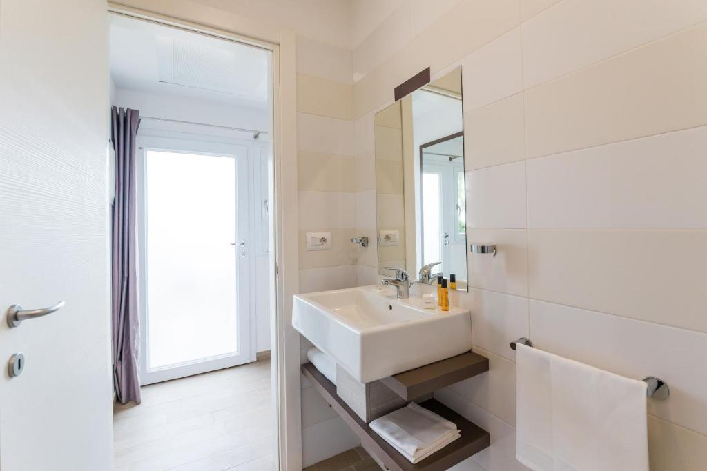 a white bathroom with a sink and a mirror at Torre Cintola Greenblu Sea Emotions in Monopoli