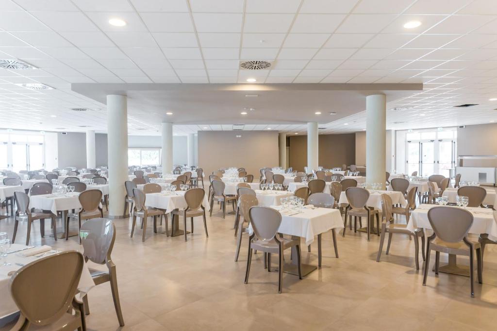 a banquet hall with white tables and chairs at Torre Cintola Greenblu Sea Emotions in Monopoli