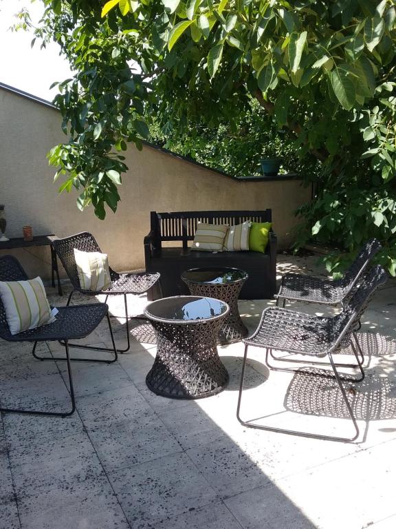 a patio with chairs and a table and a couch at Les Chambres de la Nied in Condé-Northen