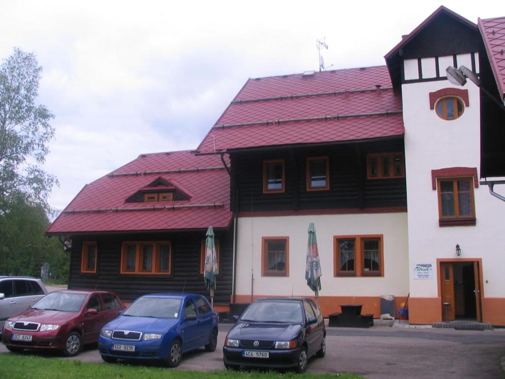 three cars parked in front of a building at Penzion Pstruh in Stožec