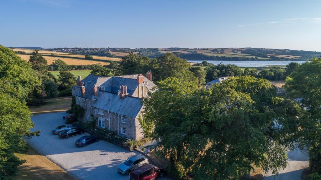 een luchtzicht op een groot huis met auto's aan de voorkant bij Trewornan Manor in Wadebridge