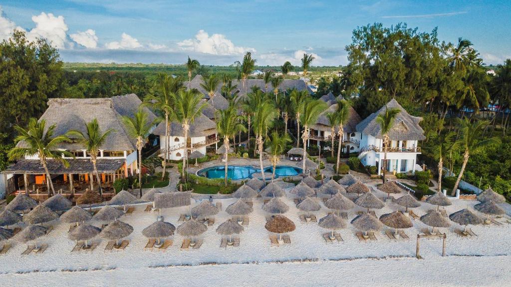 普瓦尼麥坎加尼的住宿－AHG Waridi Beach Resort & SPA，享有带稻草伞的度假村的空中景致