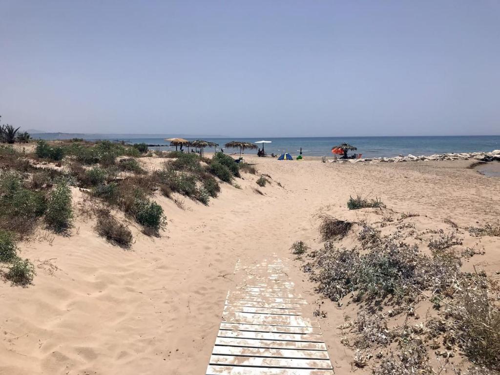 a beach with a wooden path leading to the ocean at Casa Alice a 100 mt dal mare, free wi-fi in Porto Palo