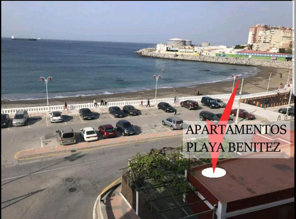 Apartamentos Playa Benitez في سبتة: اطلالة على موقف للسيارات بجانب المحيط