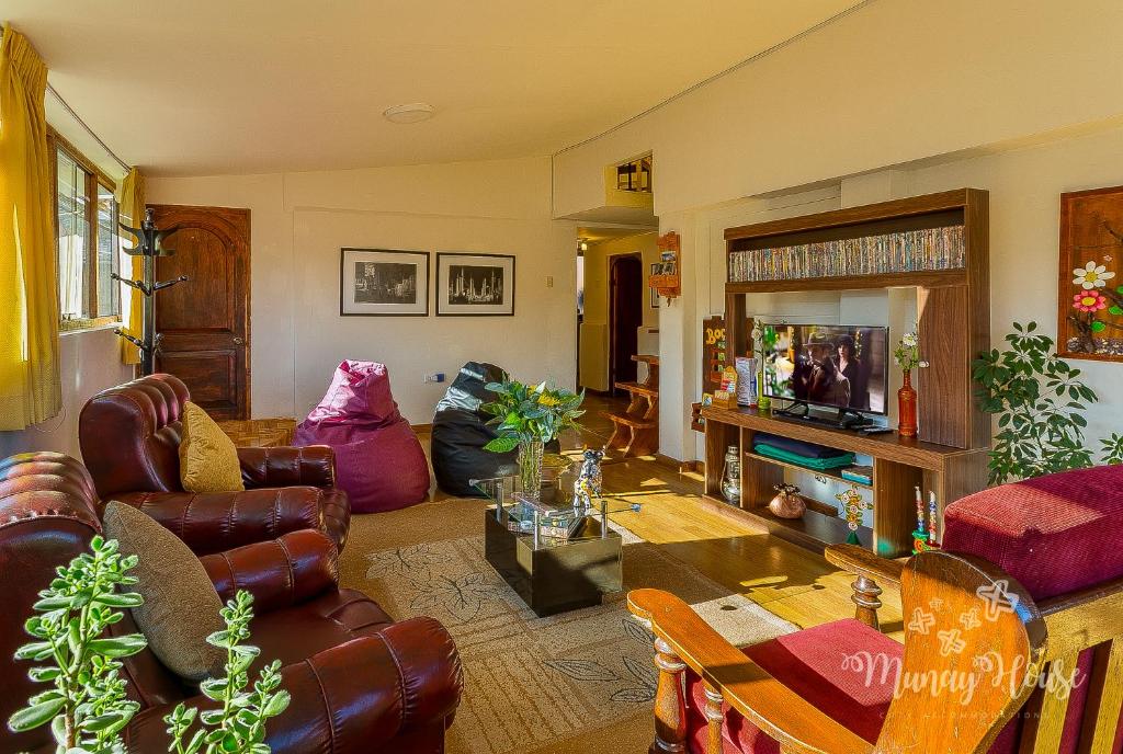 sala de estar con muebles de cuero y TV en Munay House, apartment in the center of Cusco, en Cusco