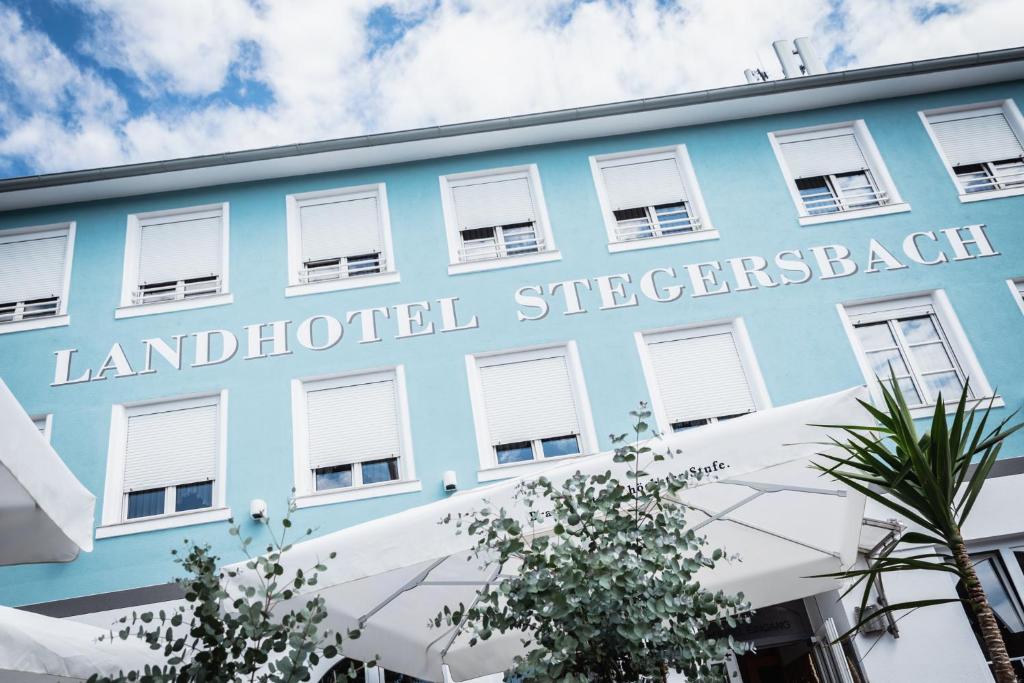 un edificio azul con las palabras Laird Hospital Sterkerk en Landhotel Stegersbach, en Stegersbach
