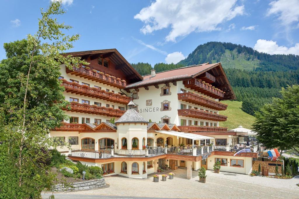 a large hotel with a mountain in the background at Hotel Singer – Relais & Châteaux in Berwang