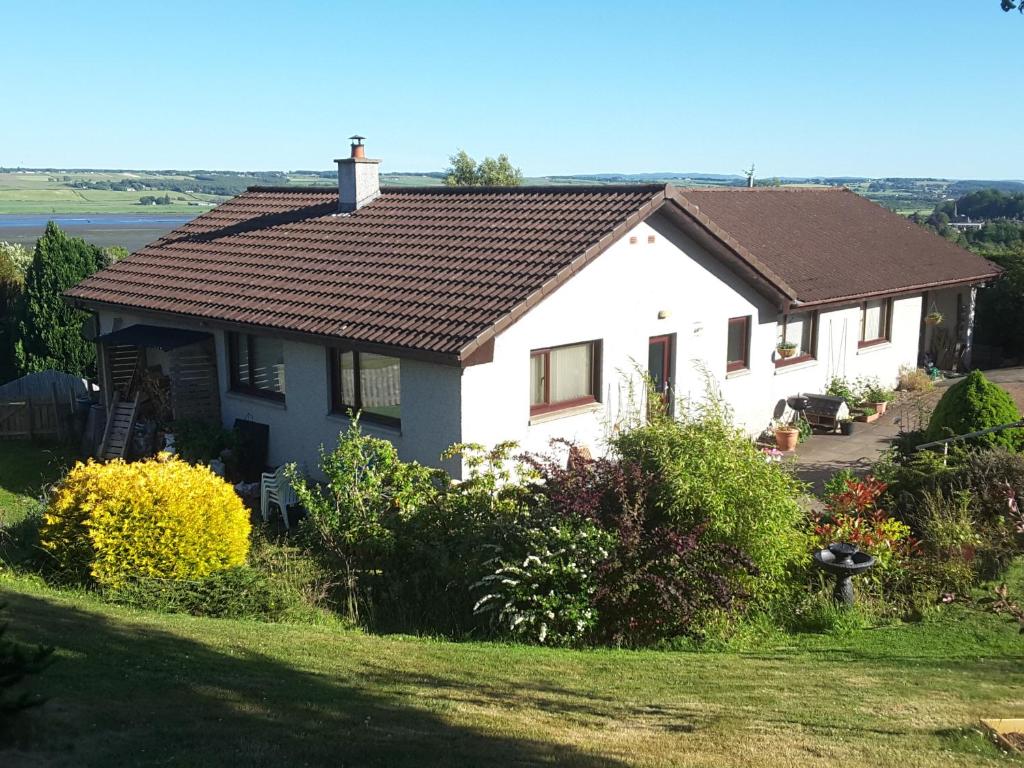 a white house with a brown roof at Black Isle View in Dingwall