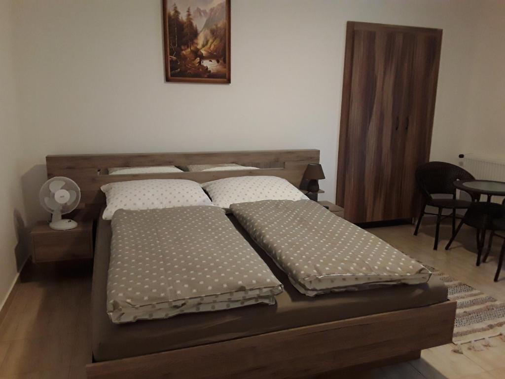 1 dormitorio con 2 camas y mesa en Mária Vendégház, en Bogács