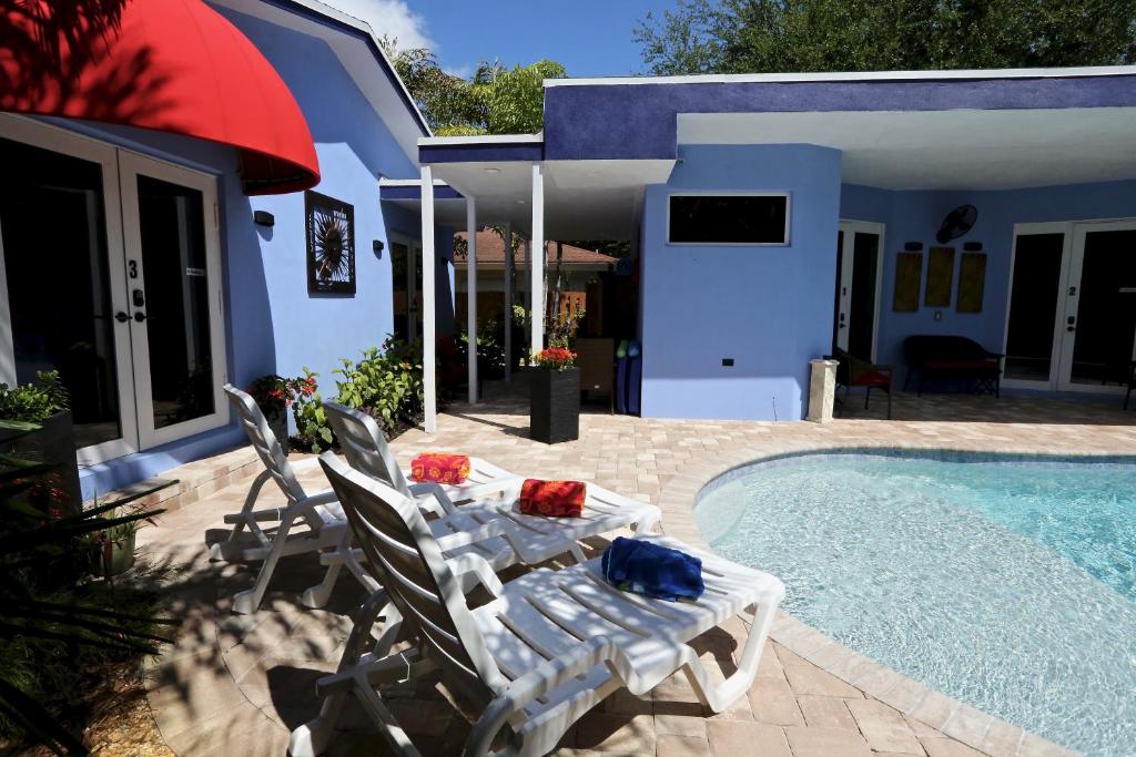 a patio with a table and chairs next to a swimming pool at Fantasy Island Inn, Caters to Men in Fort Lauderdale