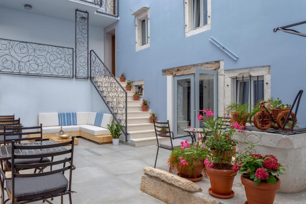 a patio with chairs and a table with flowers at Boutique Rooms Mirabilis in Skradin