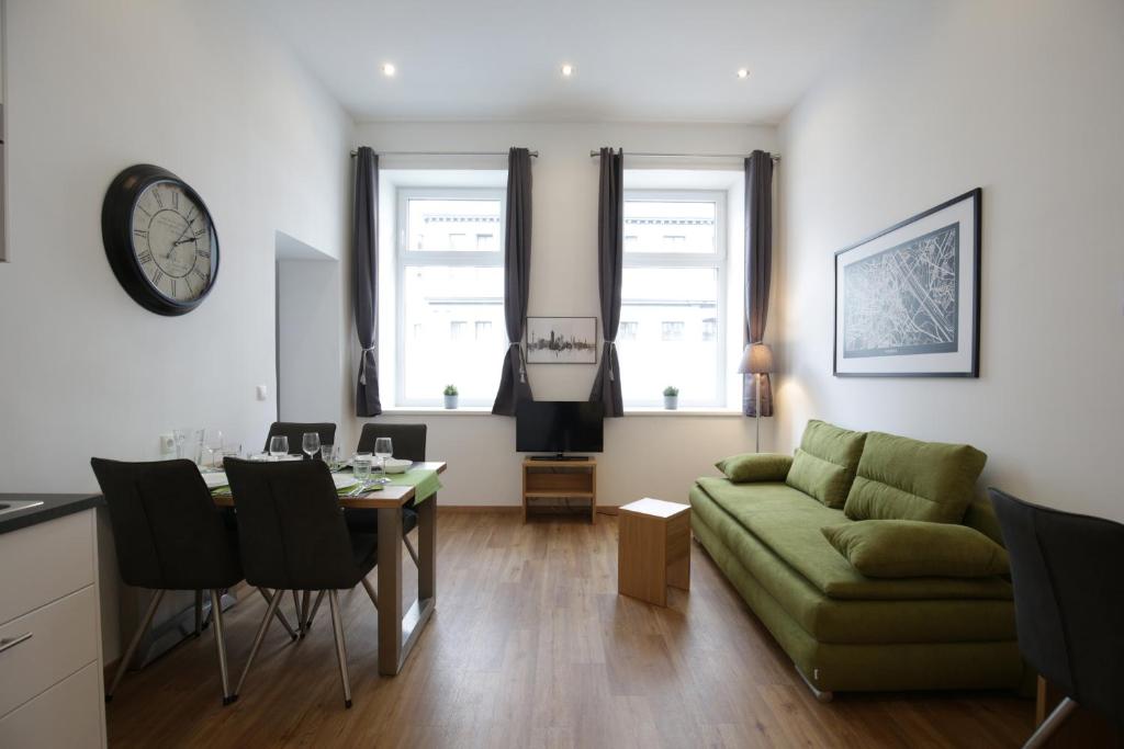 - un salon avec un canapé vert et une table dans l'établissement Vienna Gold Apartments - contactless check in, à Vienne