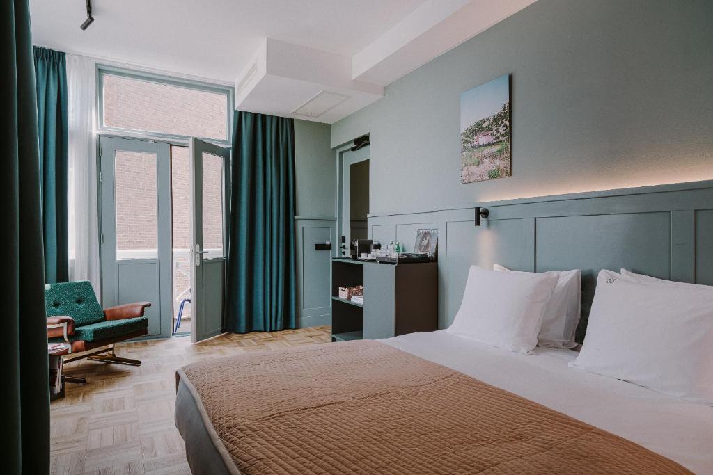 Supernova Hotel في روتردام: غرفة نوم بسرير وكرسي ونوافذ