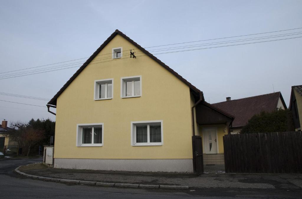 a yellow house with three windows on a street at Ubytování Bor in Bor