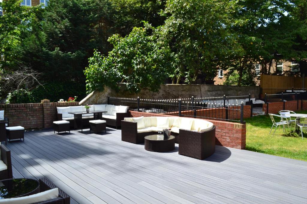 a patio with couches and chairs and a table at My Place Hotel in London