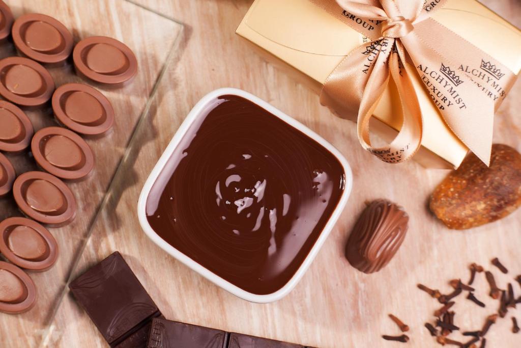 a bowl of chocolate next to a group ofocolates at Alchymist Grand Hotel and Spa - Preferred Hotels & Resorts in Prague