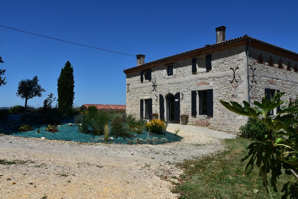 una antigua casa de piedra con un jardín delante de ella en Domaine de calbiac, en Dolmayrac