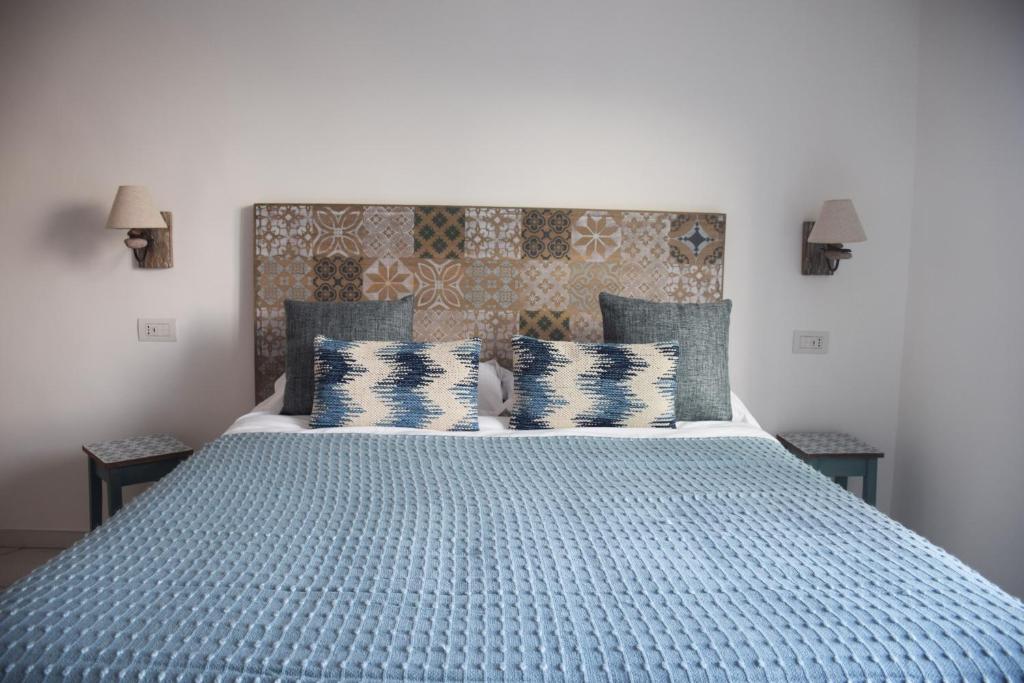 a bedroom with a large blue bed with pillows at Torre Elisea in Minori