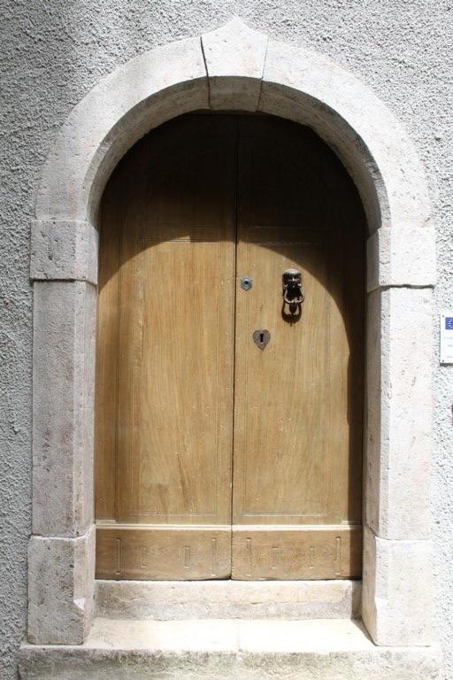 a wooden door in a building with an arch at Affitti brevi FESAGI in Laurino