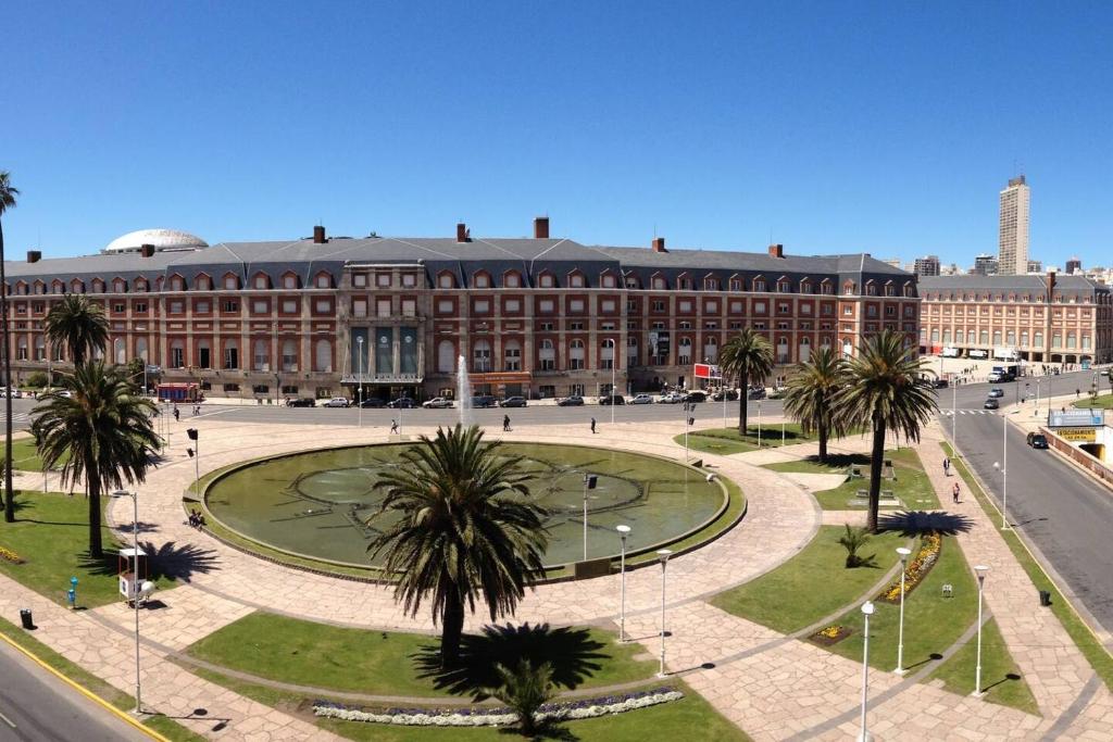 a large building with a fountain in front of a street at Frente al Mar y Casino - La mejor ubicacion en Mar del Plata in Mar del Plata