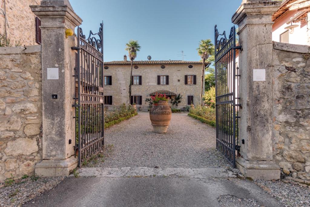 a gate with a large vase in the middle of a building at Agriturismo Tenuta Di Mensanello in Colle Val D'Elsa