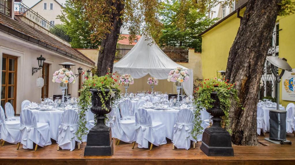 a table set up for a wedding with white tables and flowers at Alchymist Grand Hotel and Spa - Preferred Hotels & Resorts in Prague