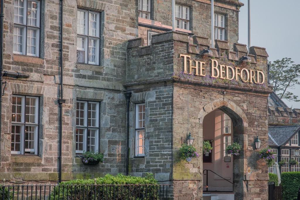 an old brick building with a sign that reads the bedford at Bedford Hotel in Tavistock