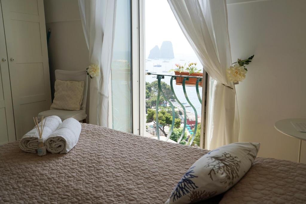 sypialnia z łóżkiem i dużym oknem w obiekcie La Finestra sui Faraglioni w mieście Capri