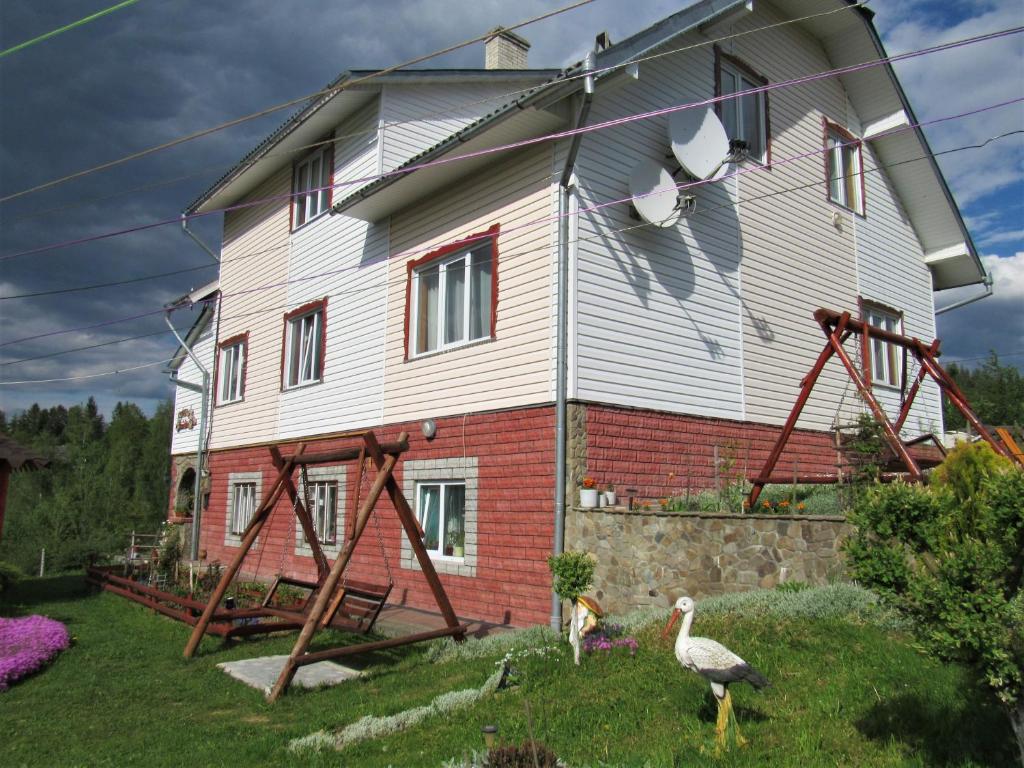 a house with two birds standing in front of it at Відпочинок у Пронів in Slavske