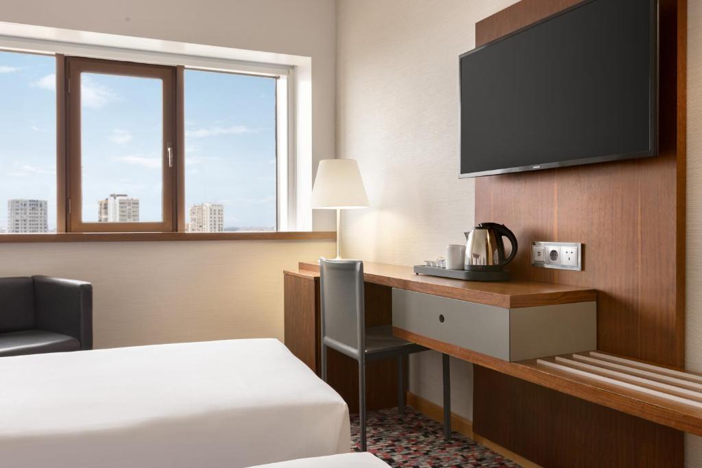 A compact desk and beverage station beside a city-facing window.