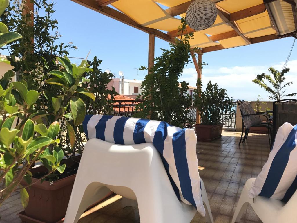 un patio con piante e sedia a strisce bianche e blu di Marisia Apartment II a Città di Zante