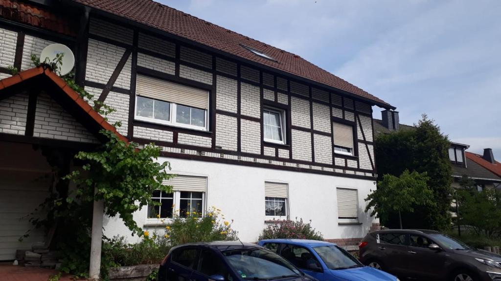 un bâtiment noir et blanc avec des voitures garées devant lui dans l'établissement Ferienwohnung Deichsel, à Sundern