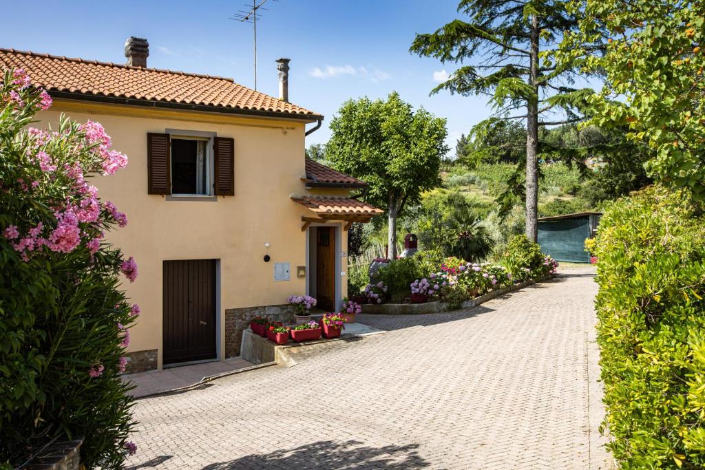 ein Haus mit einer Auffahrt und Blumen in der Unterkunft Casa Damiano in Chianni