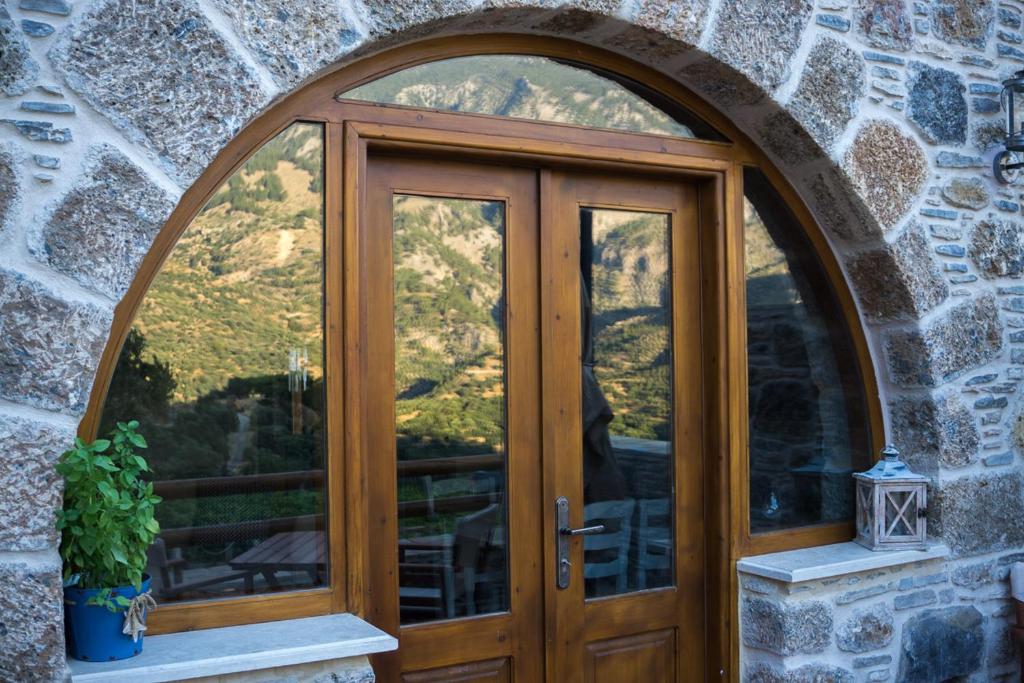 an arched wooden door in a stone building at To Spiti mas in Sougia