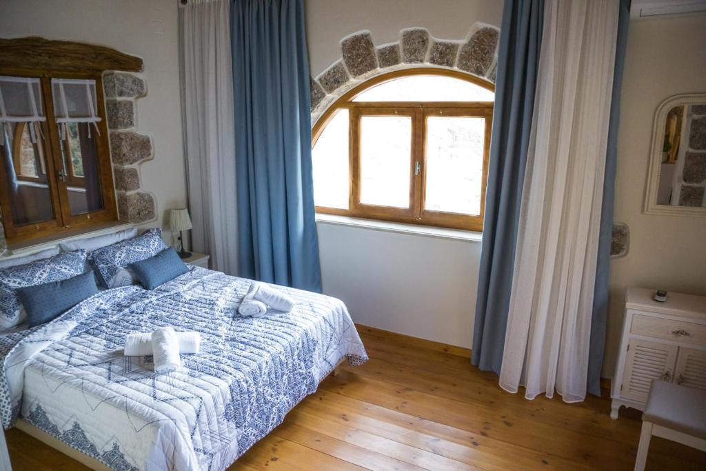 a bedroom with a bed and a large window at To Spiti mas in Sougia