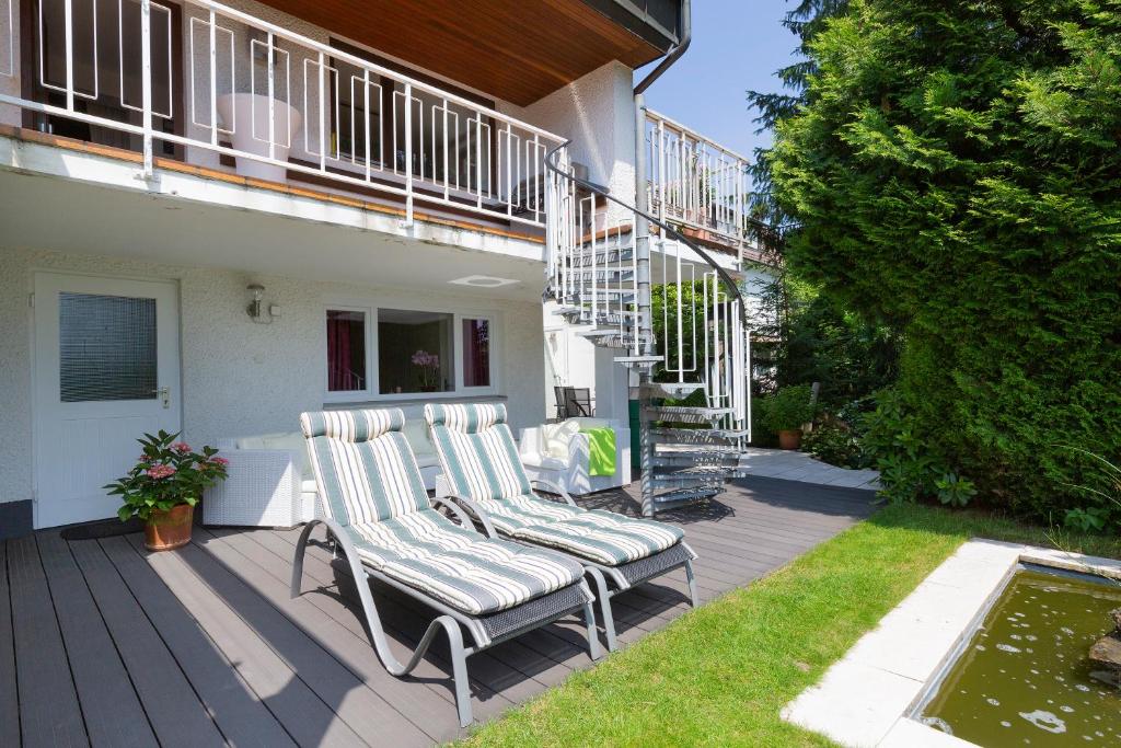 dos sillas sentadas en una terraza junto a una casa en FeWo Sommerhalde en Althütte